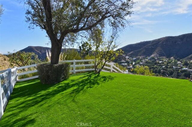 view of yard with fence and a mountain view