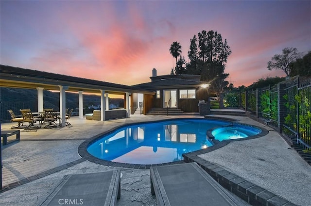 pool at dusk featuring a patio area