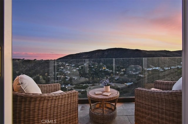 balcony at dusk with a mountain view and a patio