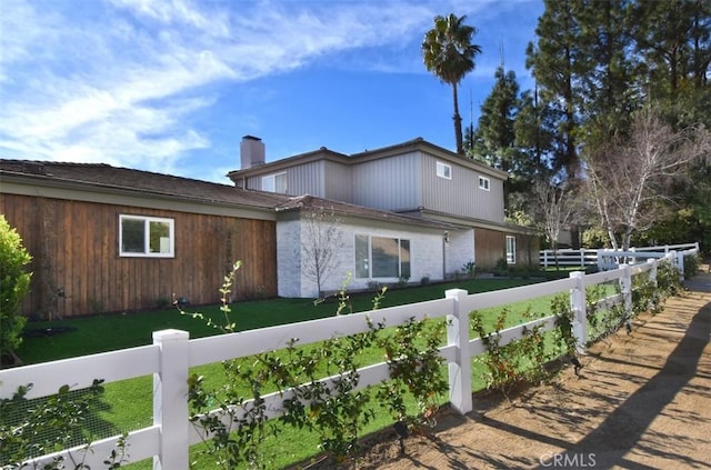 exterior space featuring a chimney and fence