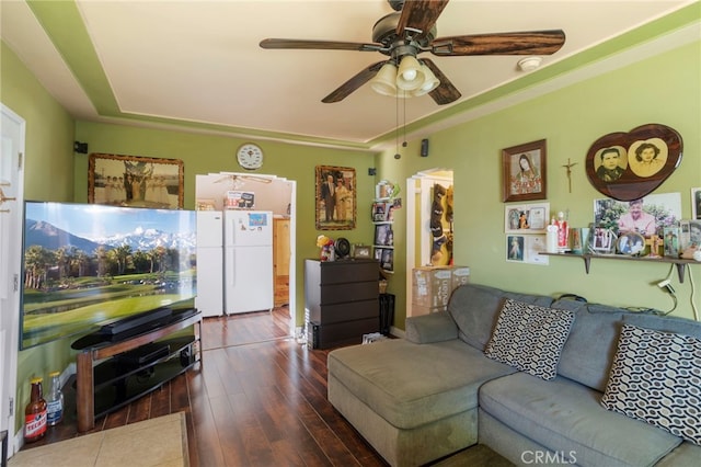 living room with ceiling fan, dark hardwood / wood-style flooring, and a raised ceiling