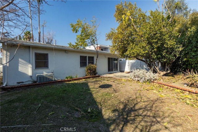 back of property featuring central AC and a yard