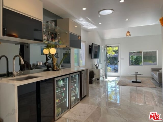 bar featuring sink and beverage cooler