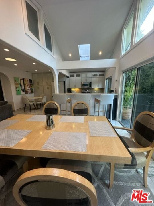 dining space with a skylight and a towering ceiling