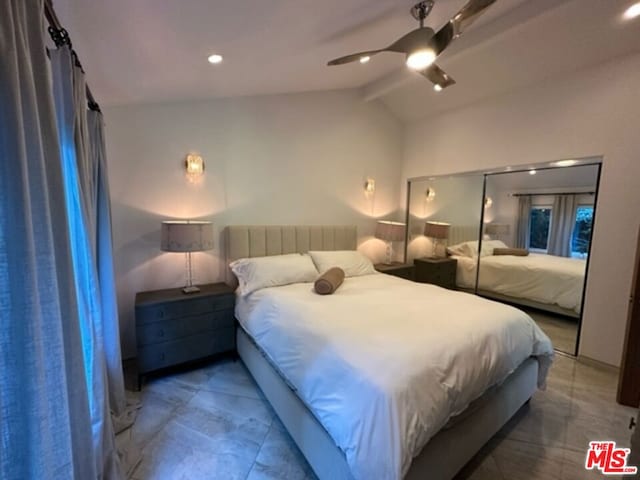 bedroom featuring ceiling fan, a closet, and lofted ceiling with beams