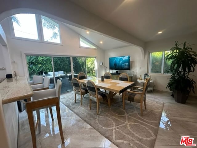 dining area featuring vaulted ceiling and a healthy amount of sunlight