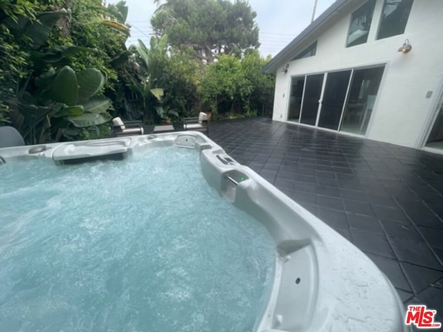 view of pool with a hot tub