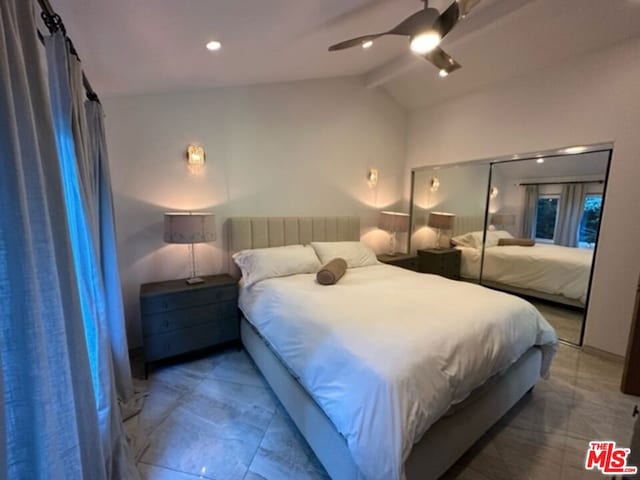 bedroom with ceiling fan, a closet, and vaulted ceiling with beams