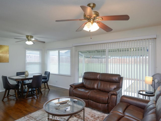 living room featuring ceiling fan and dark hardwood / wood-style floors