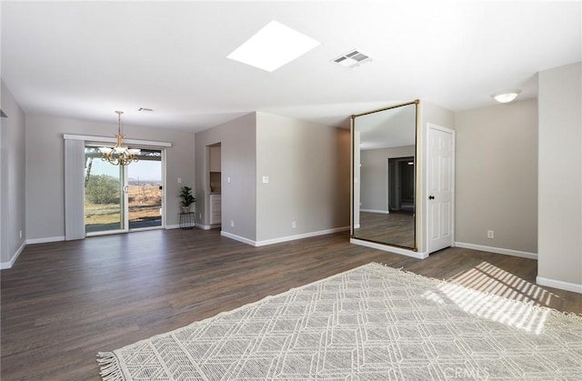 empty room featuring dark hardwood / wood-style flooring and a chandelier