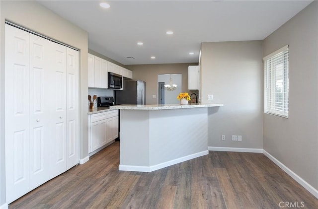 kitchen with white cabinetry, kitchen peninsula, stainless steel fridge, dark hardwood / wood-style floors, and light stone counters