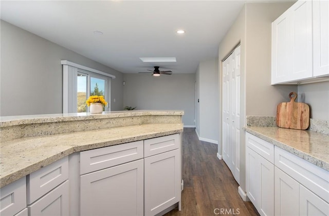 kitchen featuring dark hardwood / wood-style flooring, white cabinets, and light stone counters