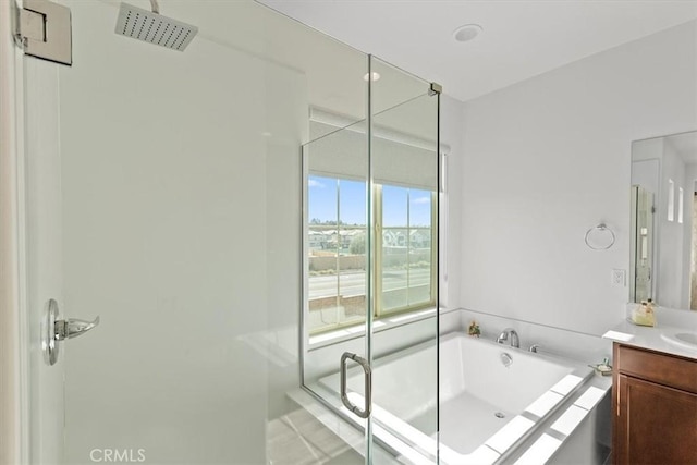 bathroom with vanity and shower with separate bathtub