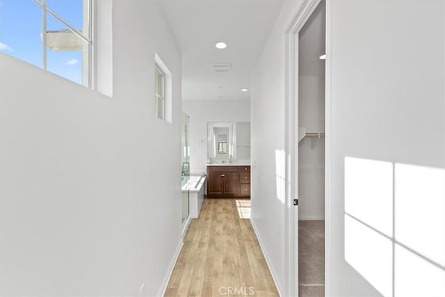 corridor with light hardwood / wood-style flooring and plenty of natural light