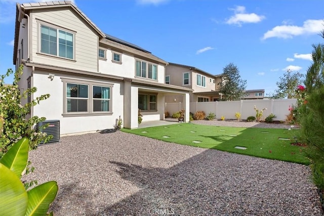 rear view of house featuring cooling unit, a patio, and a yard