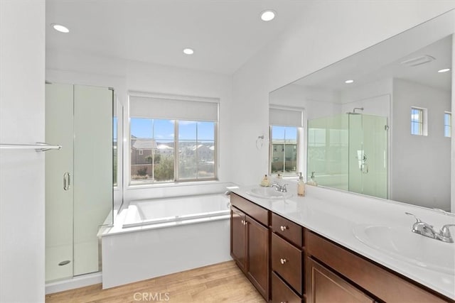 bathroom with shower with separate bathtub, hardwood / wood-style floors, and vanity