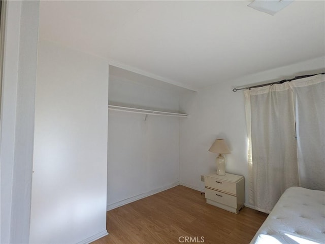 unfurnished bedroom featuring light hardwood / wood-style flooring and a closet