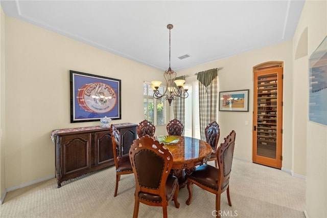 carpeted dining room featuring a chandelier