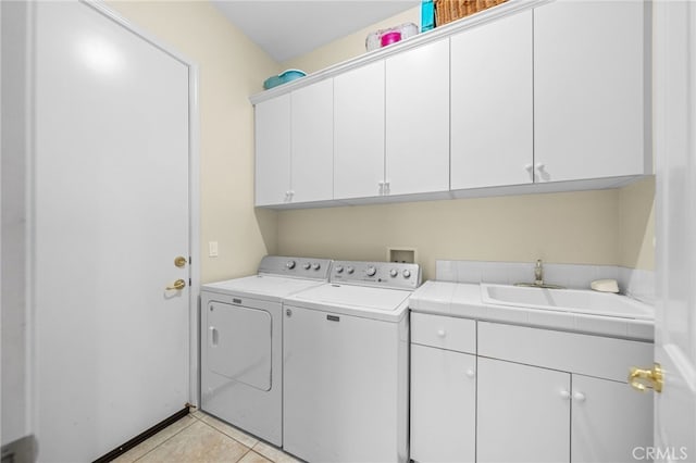 laundry room featuring cabinets, sink, washing machine and dryer, and light tile patterned floors