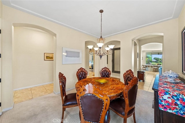 tiled dining room with a chandelier