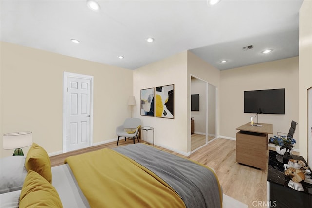 bedroom with light hardwood / wood-style floors and a closet