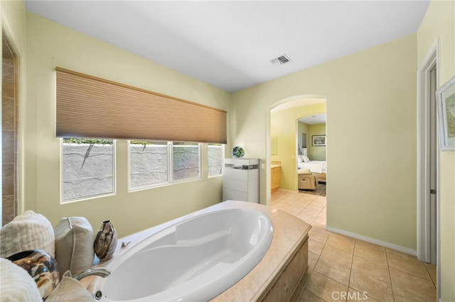 bathroom with vanity, tile patterned floors, and tiled bath