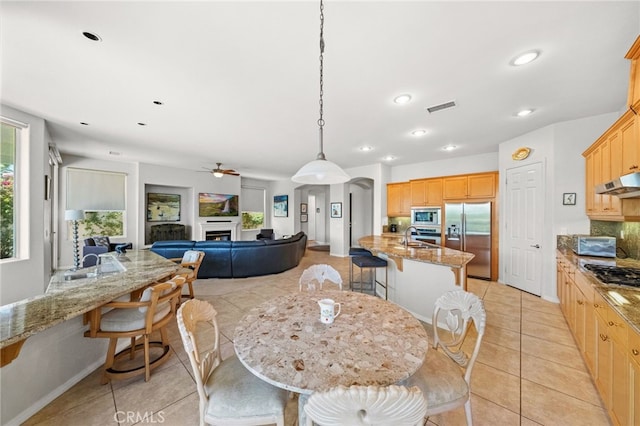 dining room featuring sink, light tile patterned floors, and ceiling fan