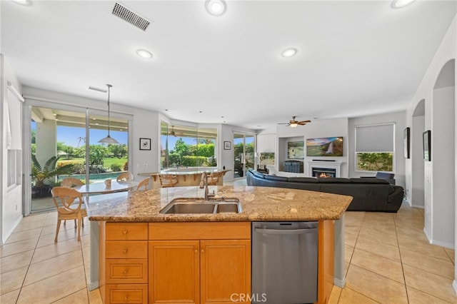 kitchen featuring dishwasher, sink, a center island with sink, and light tile patterned floors