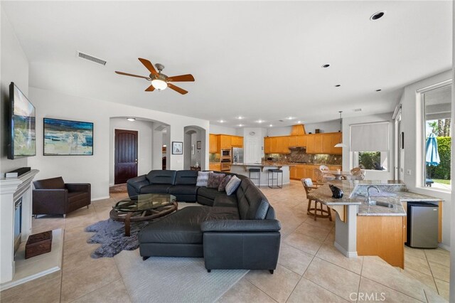 tiled living room with sink and ceiling fan