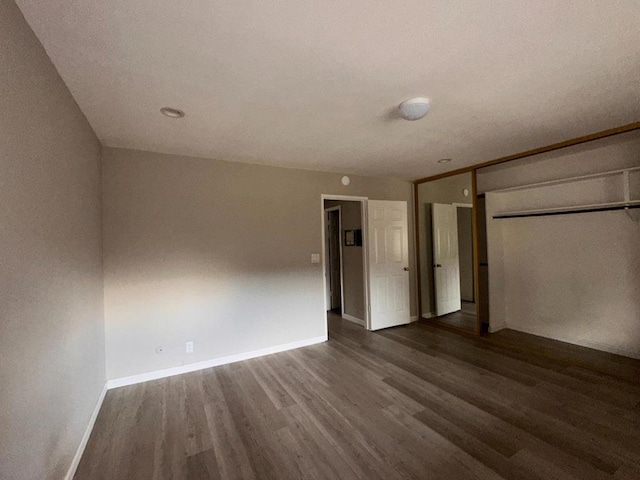 unfurnished bedroom with hardwood / wood-style flooring and a closet