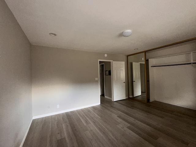 unfurnished bedroom featuring dark hardwood / wood-style floors and a closet