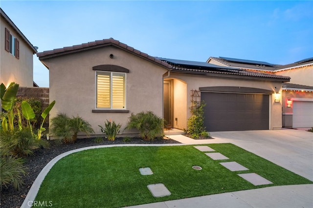 mediterranean / spanish-style home featuring a front lawn, a garage, and solar panels