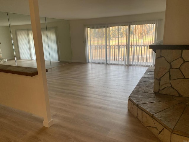 unfurnished living room featuring wood-type flooring and a wealth of natural light