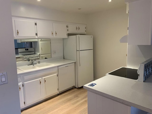 kitchen featuring white cabinets, light wood-type flooring, sink, and white appliances