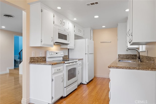 kitchen featuring light wood-type flooring, sink, white appliances, and white cabinetry