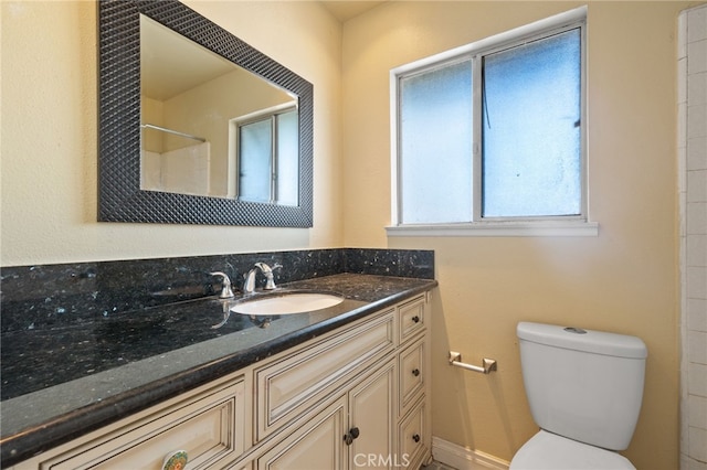 bathroom featuring a shower, toilet, and vanity