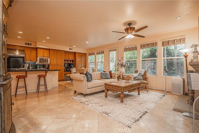 tiled living room featuring ceiling fan and plenty of natural light