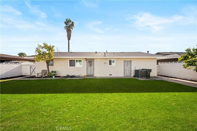 back of property with a lawn and central air condition unit