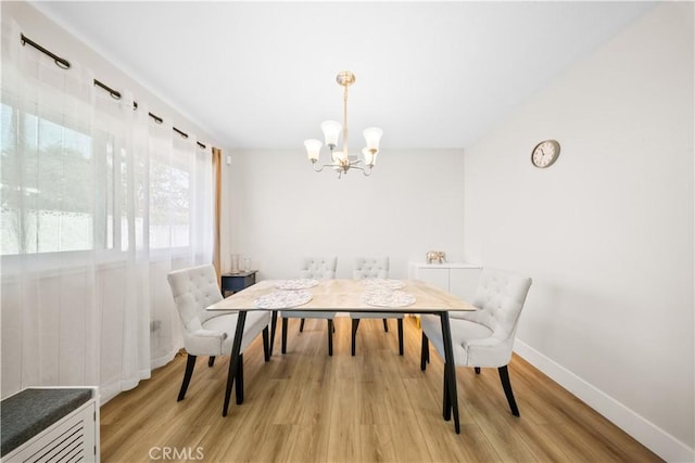 dining room with a notable chandelier and light wood-type flooring