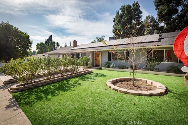 ranch-style home featuring a front lawn and solar panels