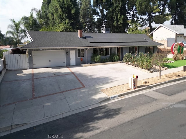 single story home featuring a garage and solar panels