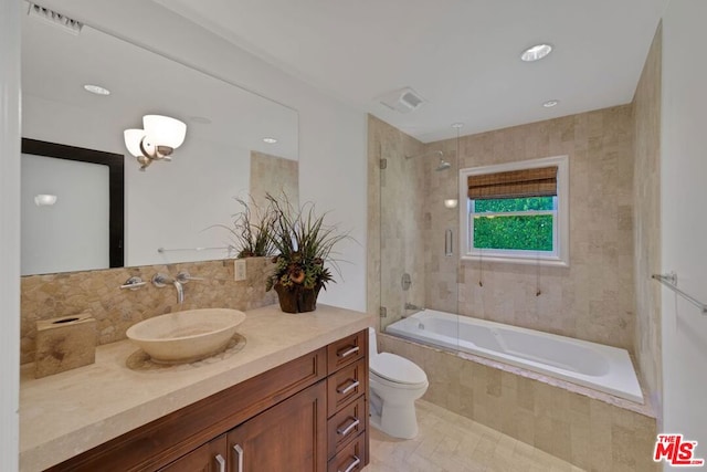 full bathroom with toilet, vanity, and tiled shower / bath combo