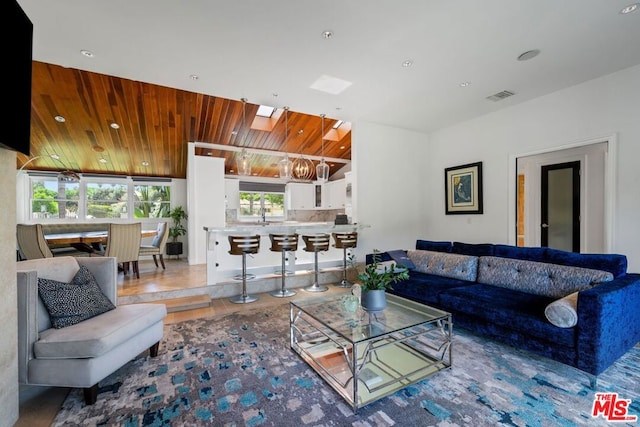 tiled living room featuring wooden ceiling and a skylight