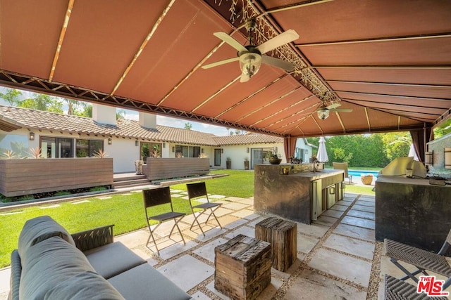 view of patio featuring ceiling fan, exterior kitchen, and an outdoor living space