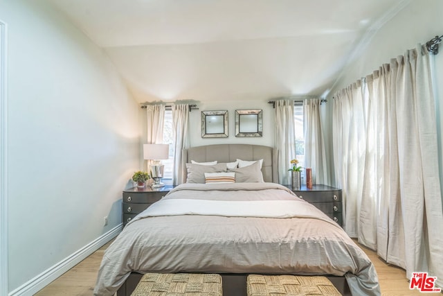 bedroom featuring lofted ceiling and light wood-type flooring