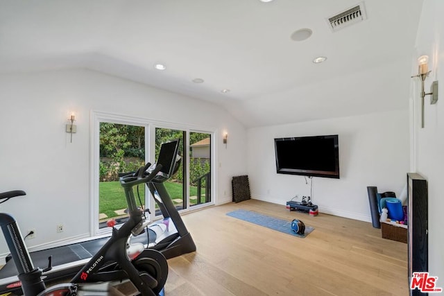 exercise area with vaulted ceiling and light hardwood / wood-style floors