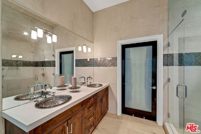 bathroom featuring tile walls, an enclosed shower, and vanity