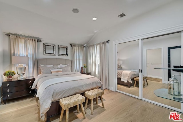 bedroom with lofted ceiling, a closet, and light hardwood / wood-style flooring