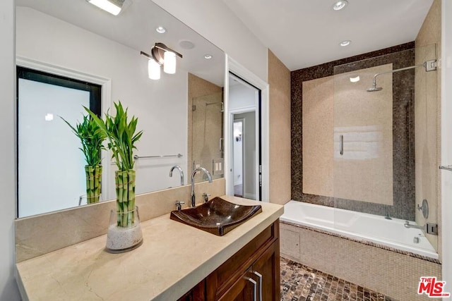 bathroom featuring tiled shower / bath combo and vanity