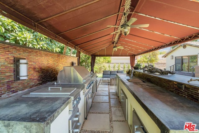 view of patio with ceiling fan, area for grilling, exterior kitchen, and sink